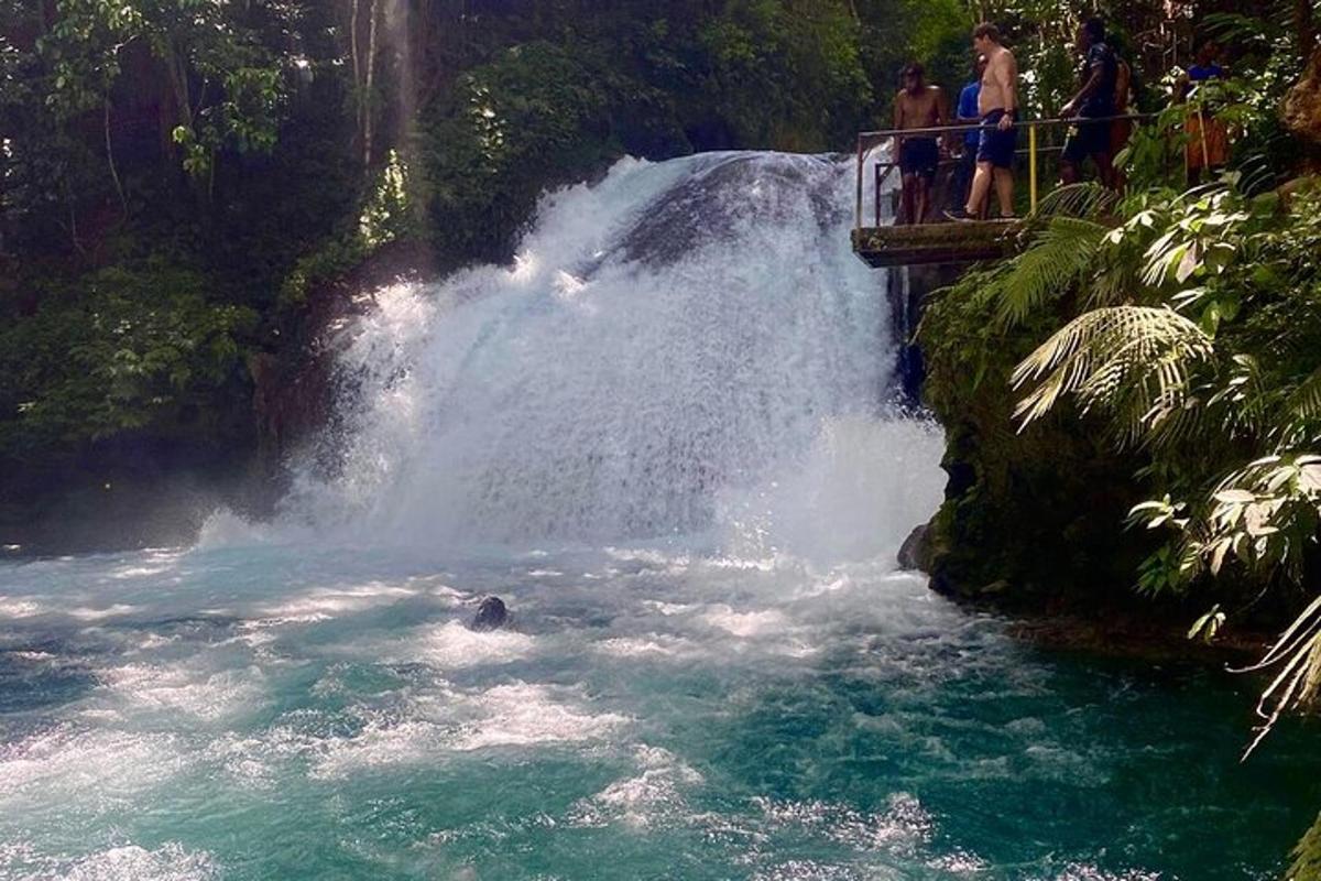 gent dempeus en un pont a prop d'una cascada