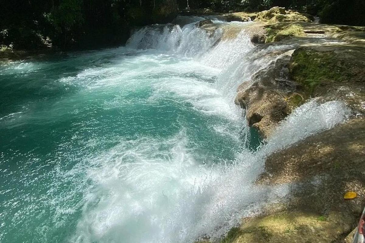 una cascada en un riu al costat d'unes roques