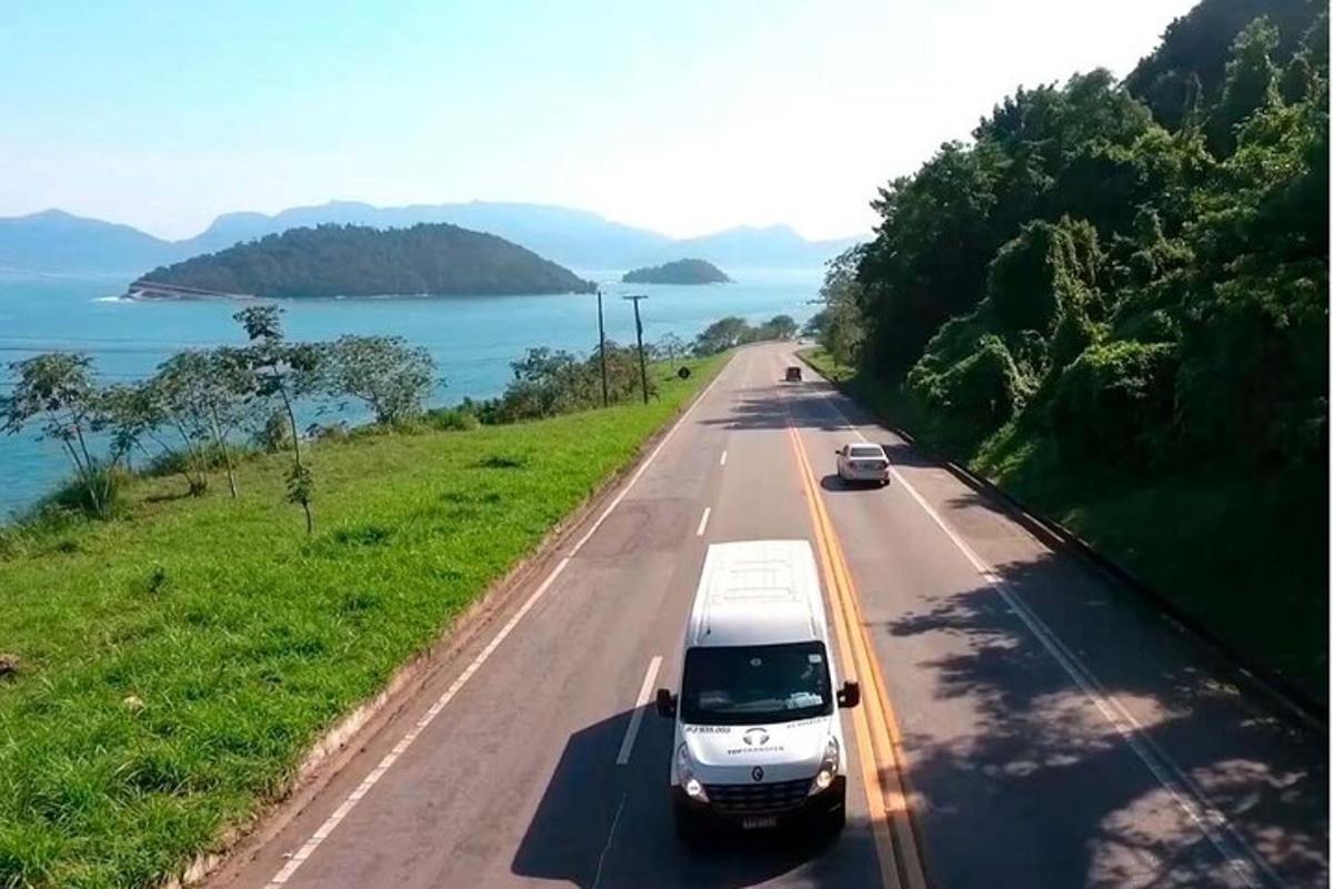 un furgone bianco che percorre una strada vicino all'acqua
