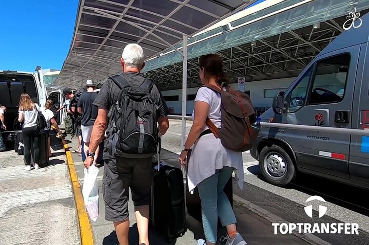 un gruppo di persone in attesa in un aeroporto con i loro bagagli