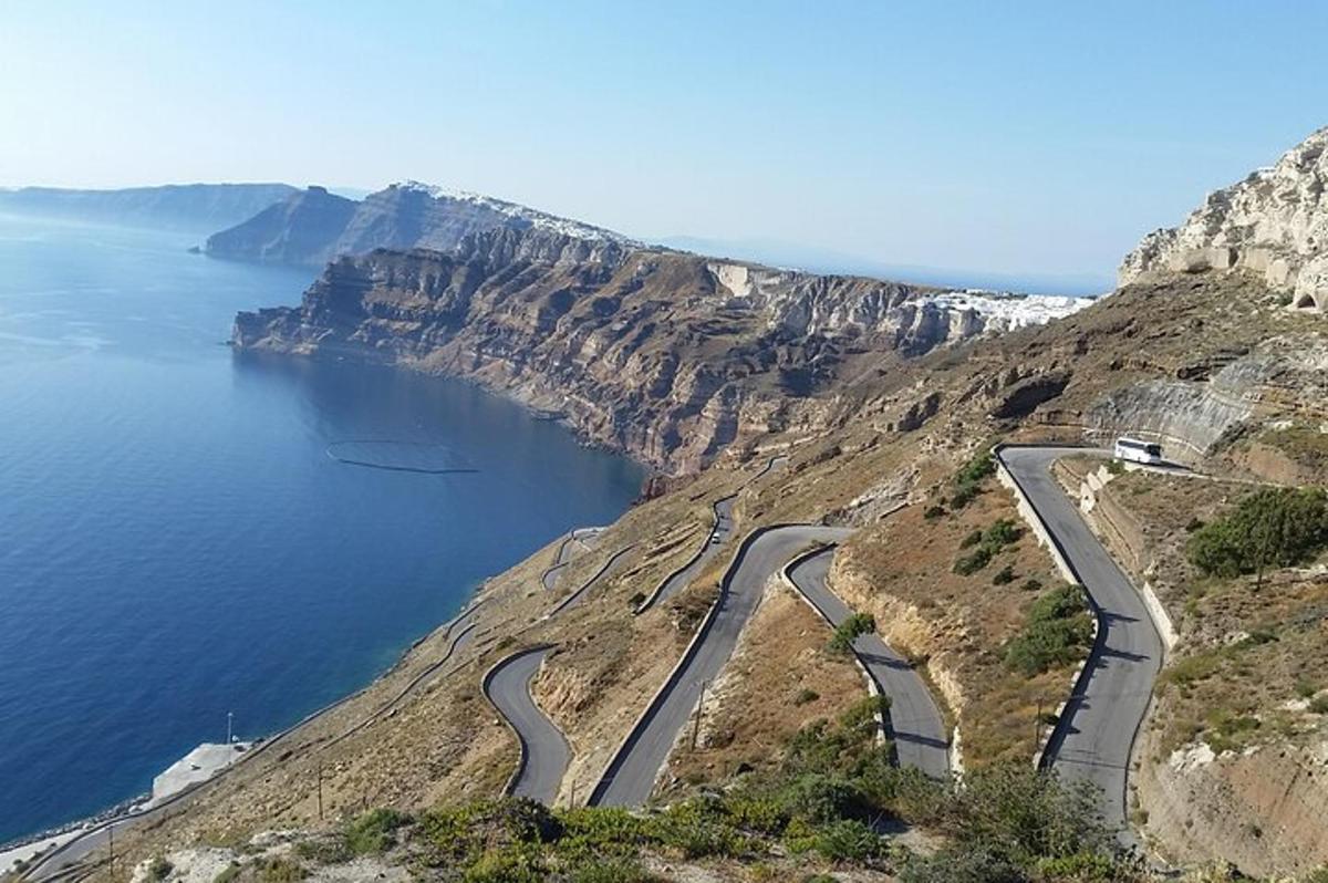eine kurvenreiche Straße auf einem Berg neben dem Meer