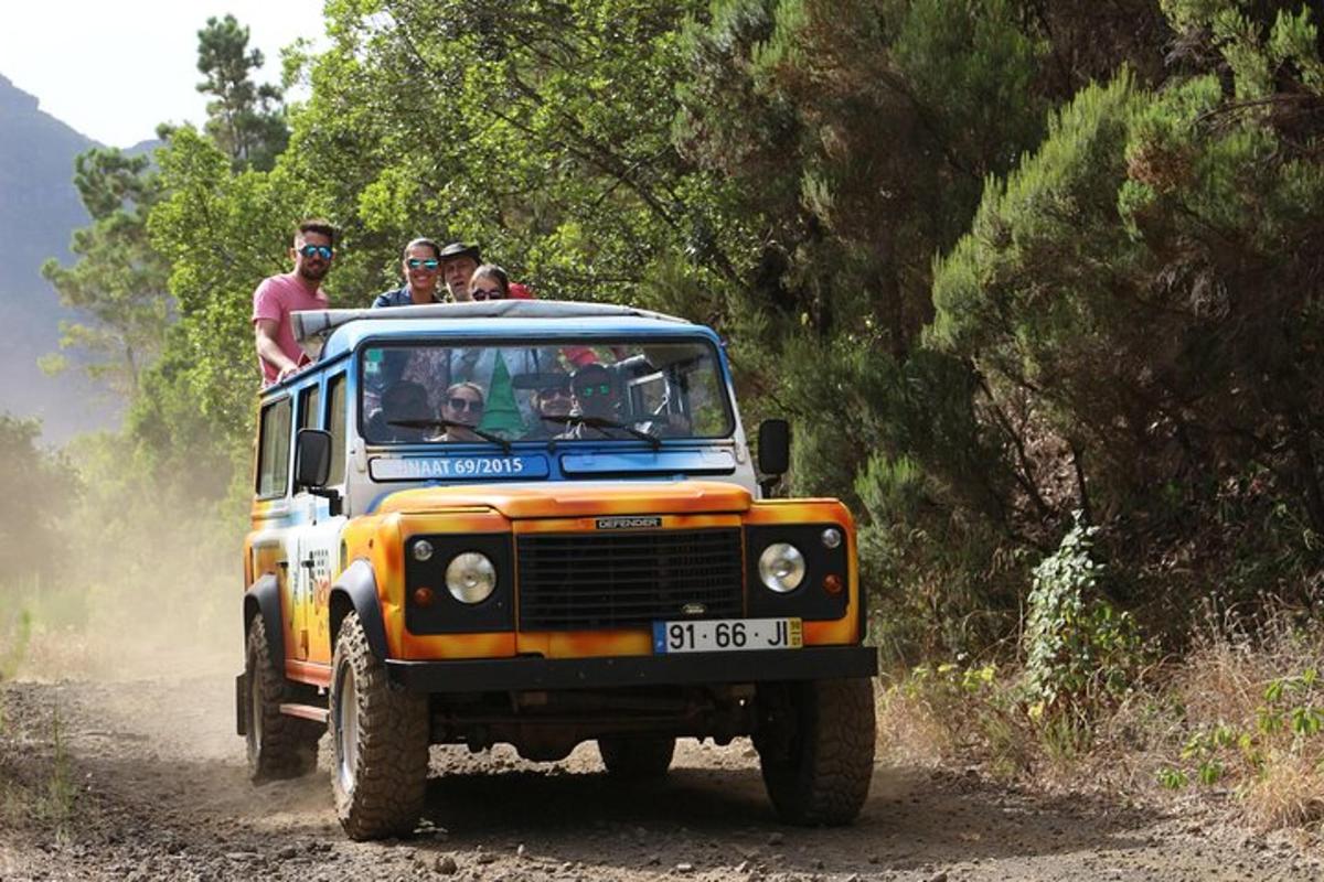 un gruppo di persone che viaggiano in jeep su una strada sterrata