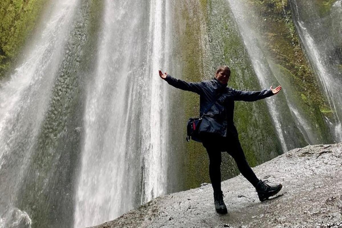 osoba stojící na skále poblíž vodopádu
