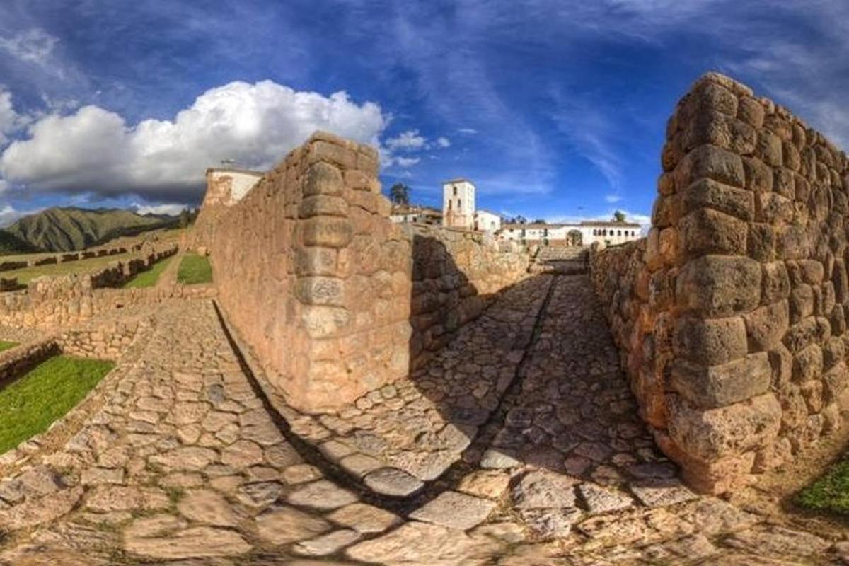 Un antiguo muro de piedra con un edificio al fondo
