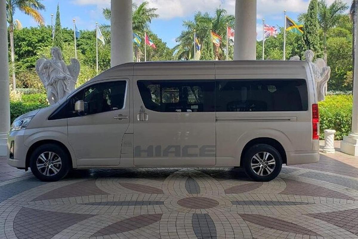 Una minivan blanca estacionada en una acera en una ciudad