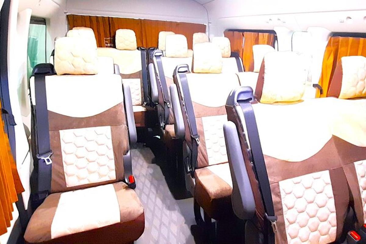 Un vagón de tren vacío con asientos blancos y marrones.