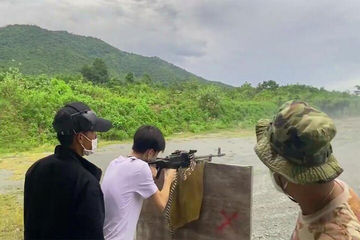a group of people aiming a gun on a road