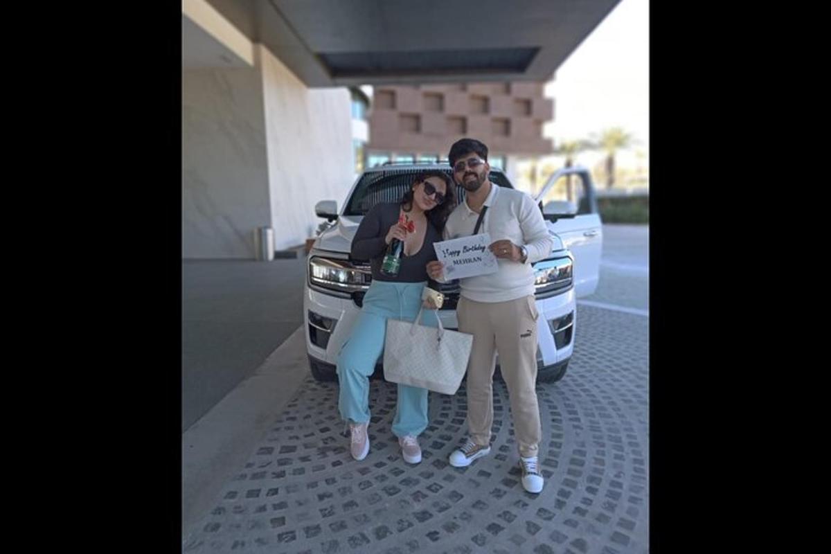 un uomo e una donna in piedi davanti a un'auto