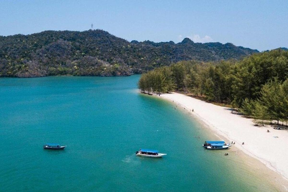 three boats in the water next to a beach
