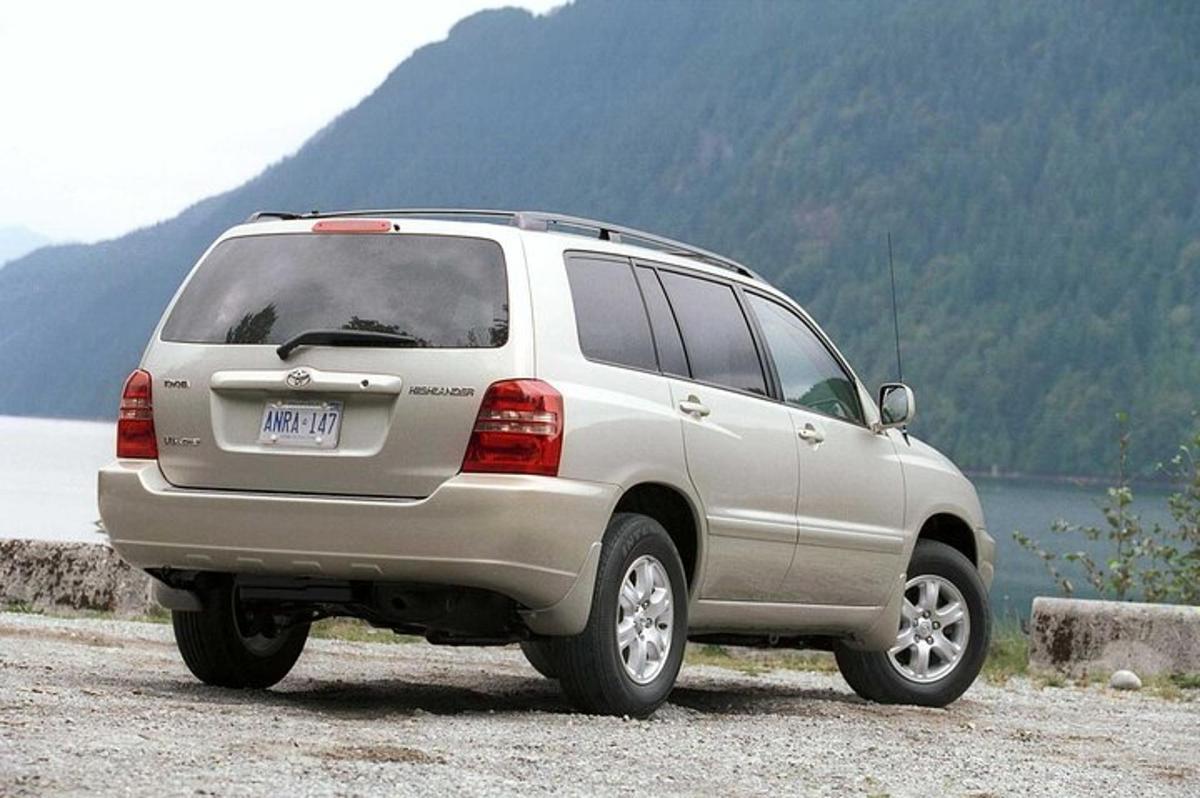 một chiếc xe suv màu bạc đỗ bên cạnh một vùng nước