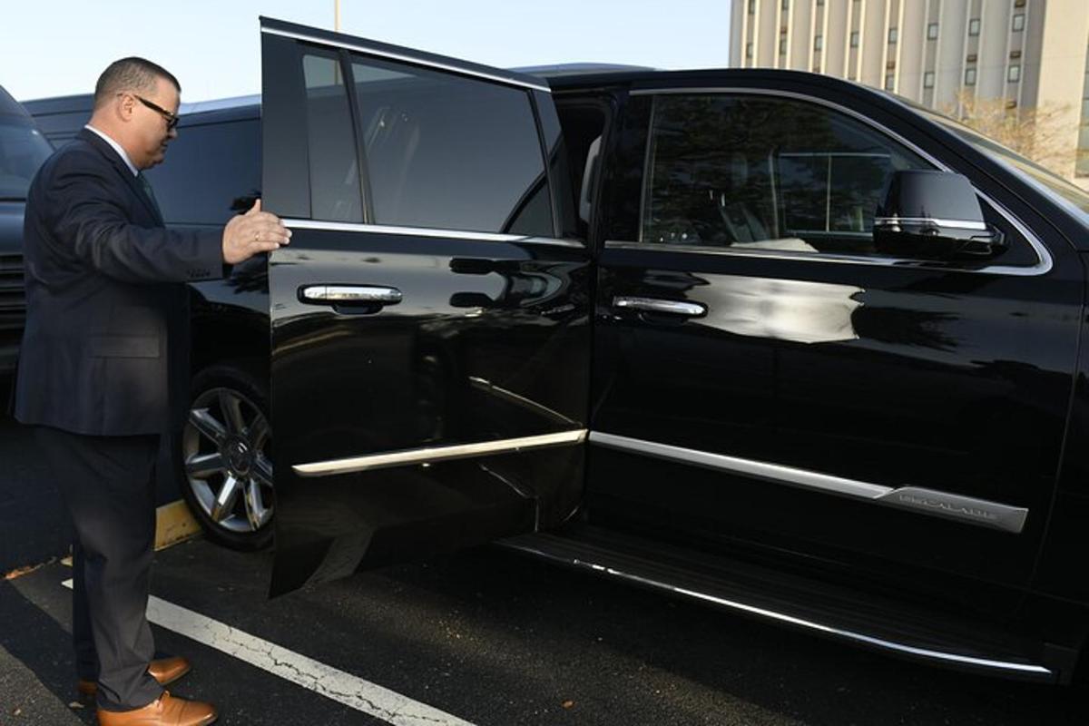 a man opening the door of a black car