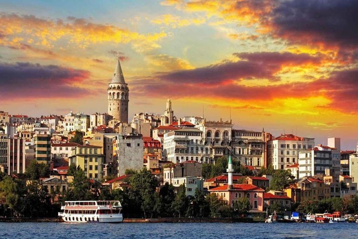 a city skyline with a boat in the water at sunset