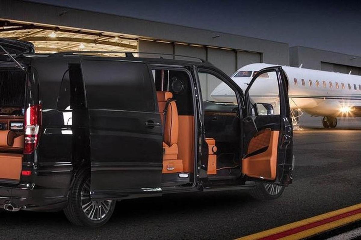 a black van parked in front of an airplane