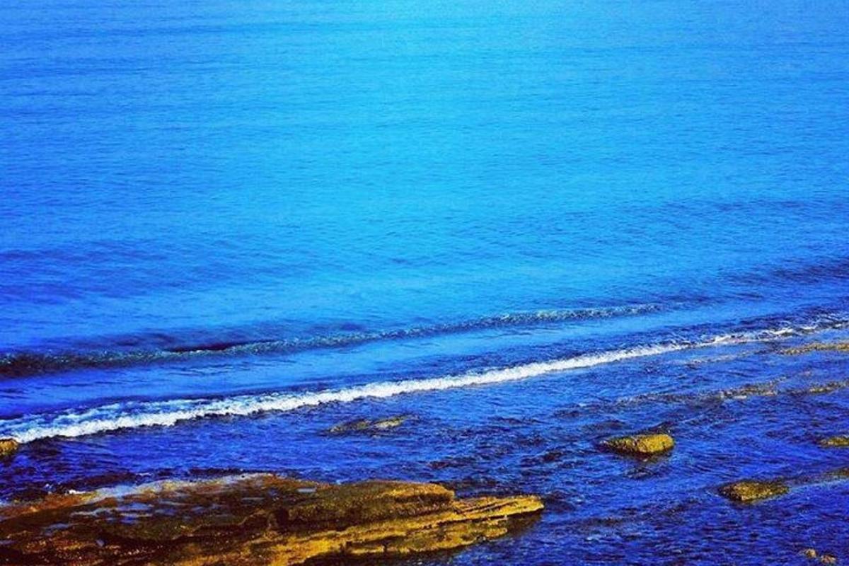 Una vista de una playa con agua azul y rocas.