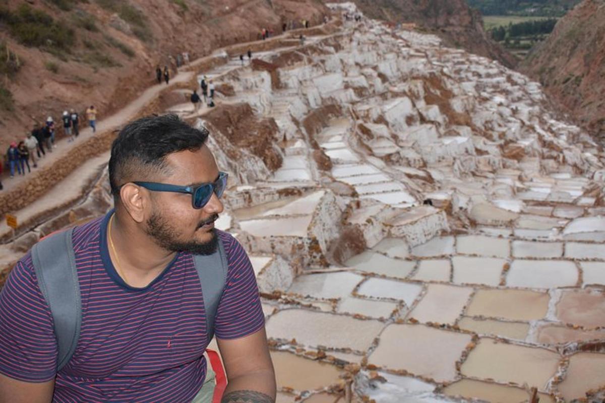 muž se slunečními brýlemi sedící před pyramidou