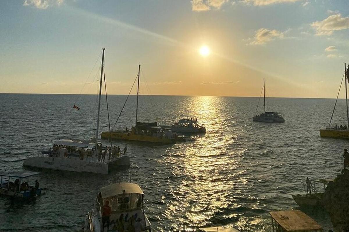 um grupo de barcos na água ao pôr do sol