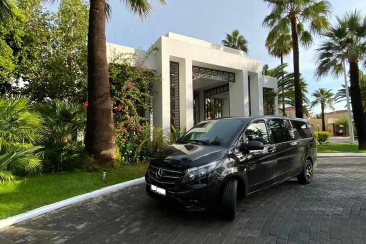 um carro preto estacionado em frente a uma casa