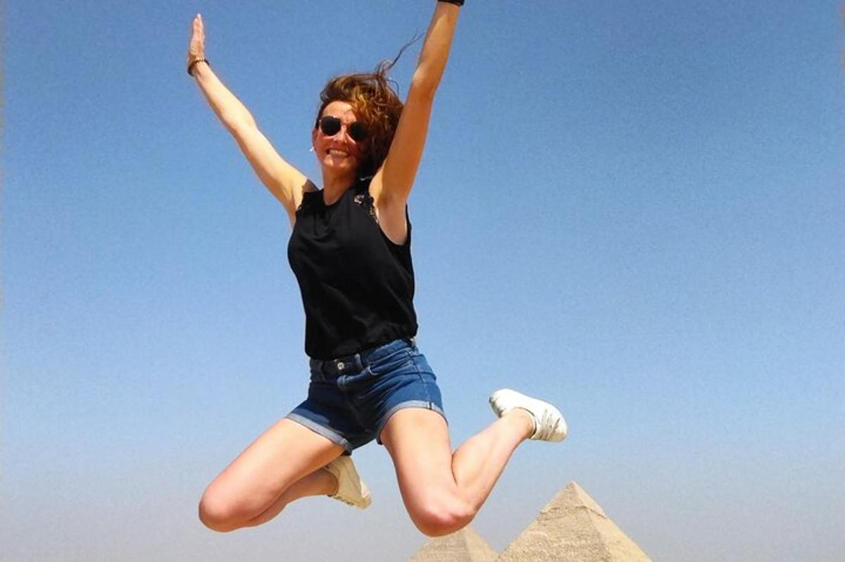 una donna che salta in aria davanti alle piramidi