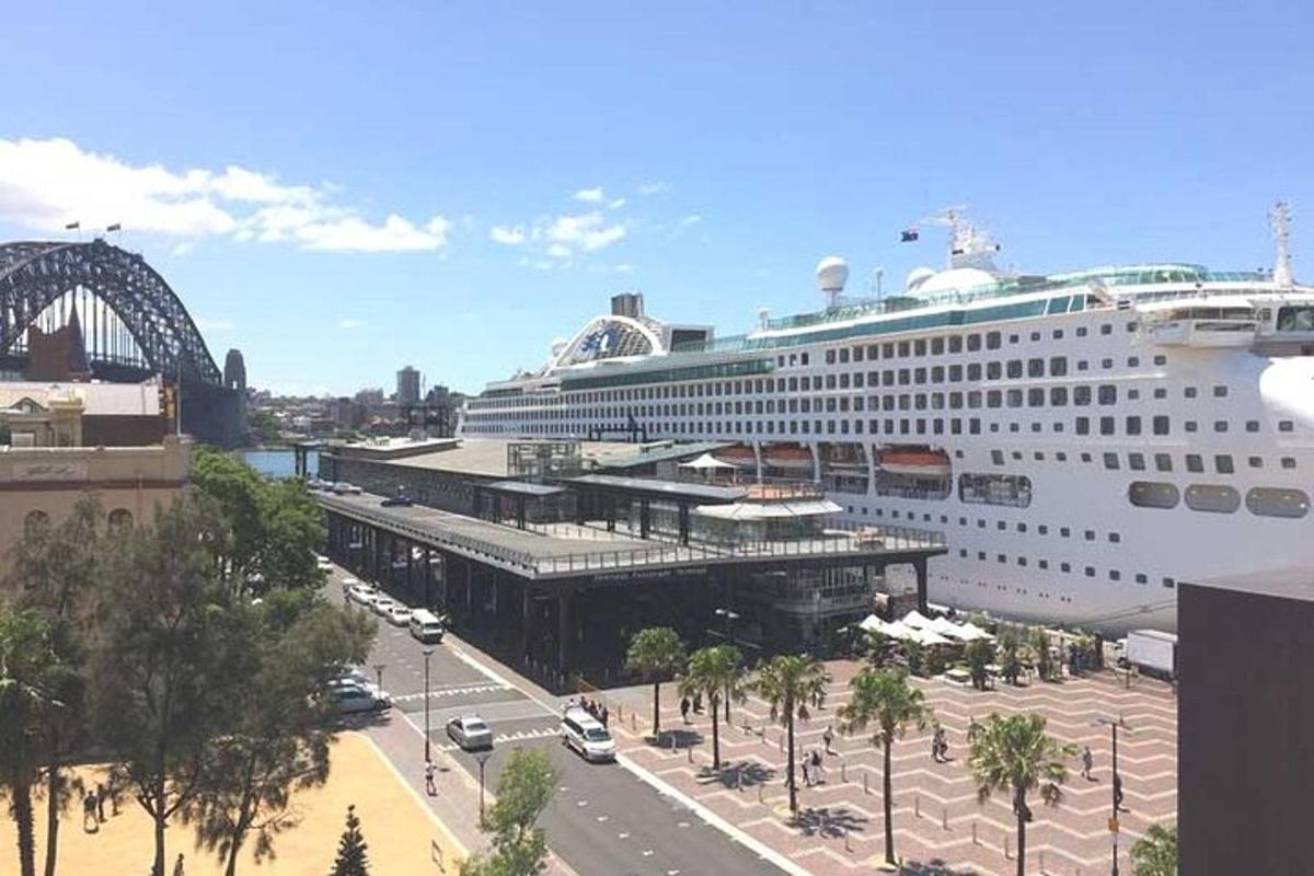 a cruise ship docked in a city with a bridge