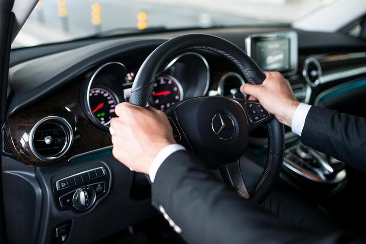 mies ajaa autoa kädet ohjauspyörällä