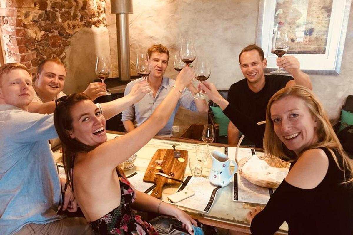 un grup de oameni așezați la o masă cu pahare de vin