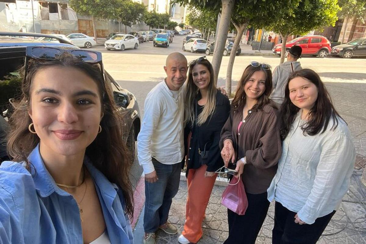 Un grupo de personas de pie junto a un coche.