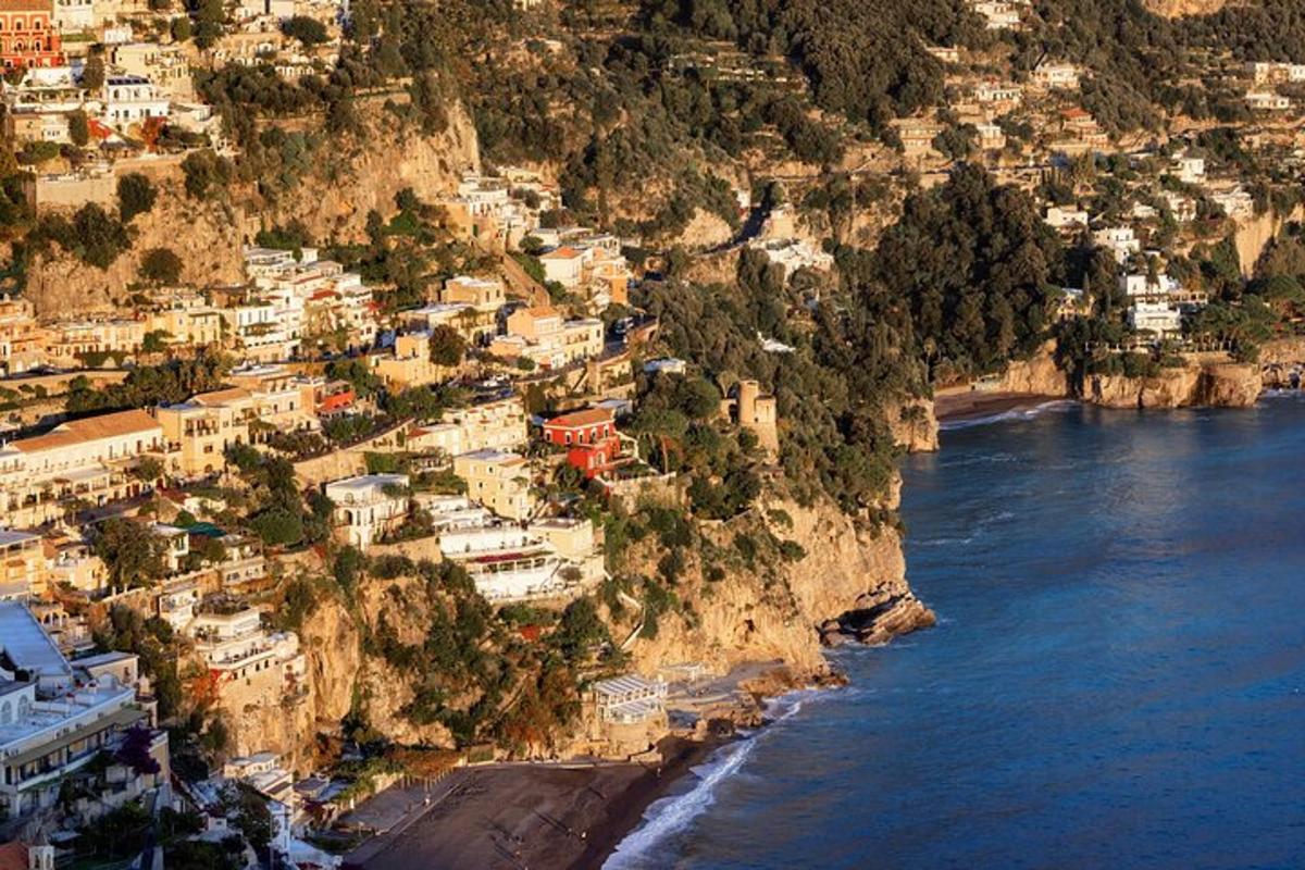 an aerial view of a town on a mountain next to the ocean
