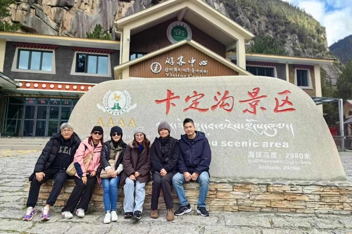 一群人坐在标志牌前