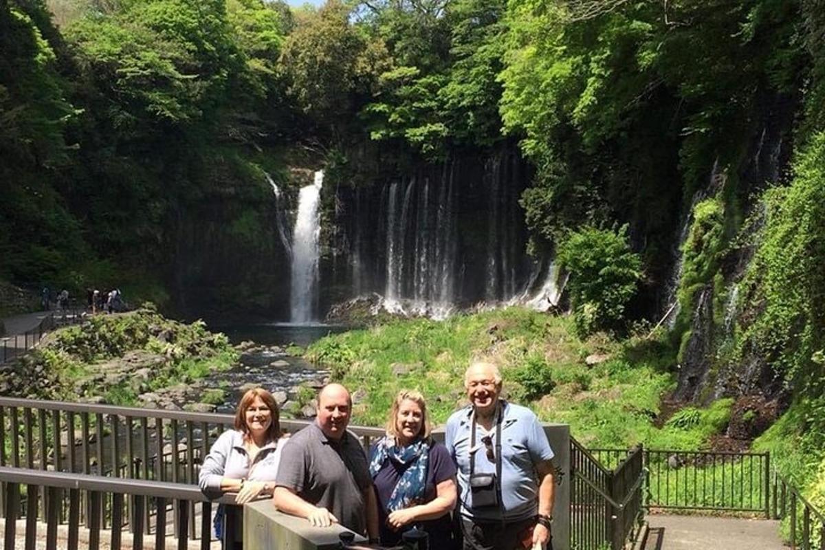 a group of people standing in front of a waterfall
