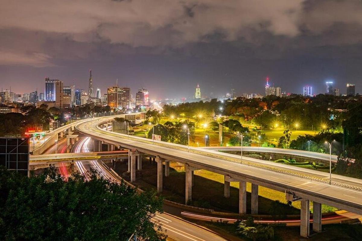 un horitzó de ciutat a la nit amb trànsit a l'autopista