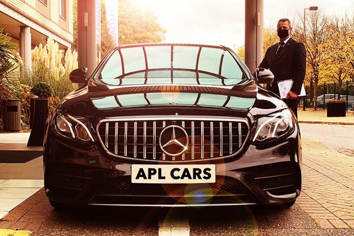 a man is standing next to a black car