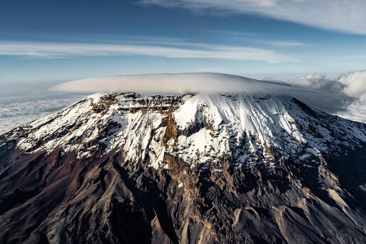 una montagna coperta di neve con una nuvola in cima