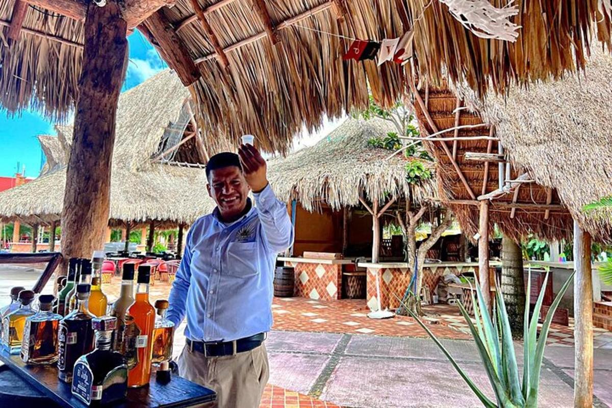 a man standing next to a table with bottles of booze