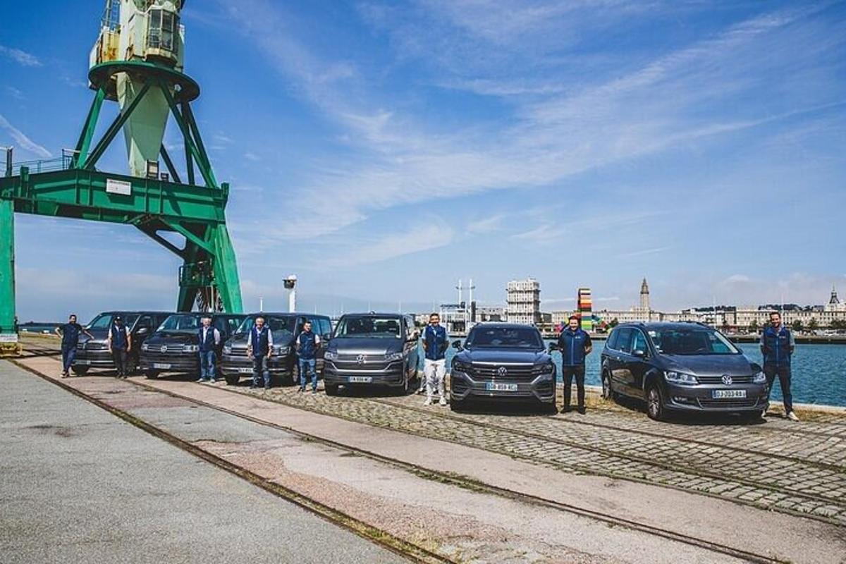 a group of people standing next to parked cars