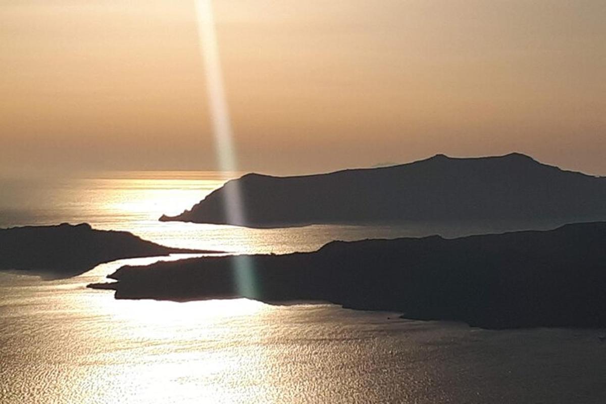 ein Sonnenuntergang über einem Gewässer mit einem Berg