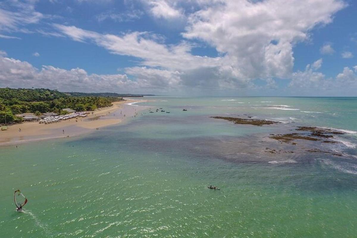 an aerial view of a beach with people in the water