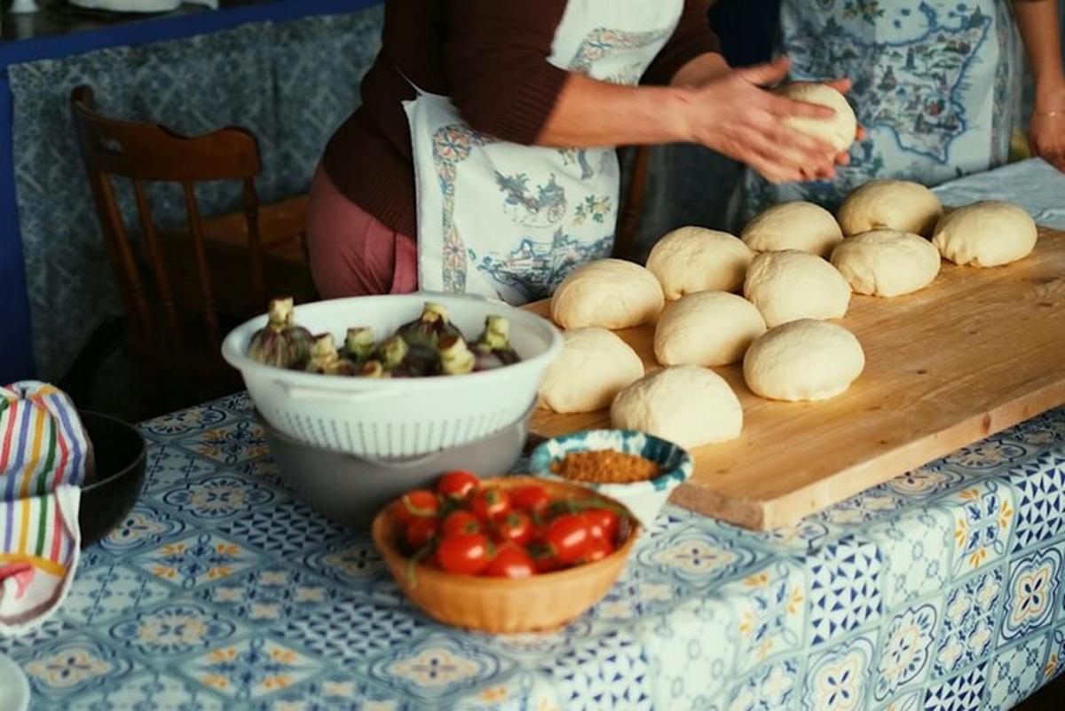 borð með skurðarbretti með lauk og skál af tómötum