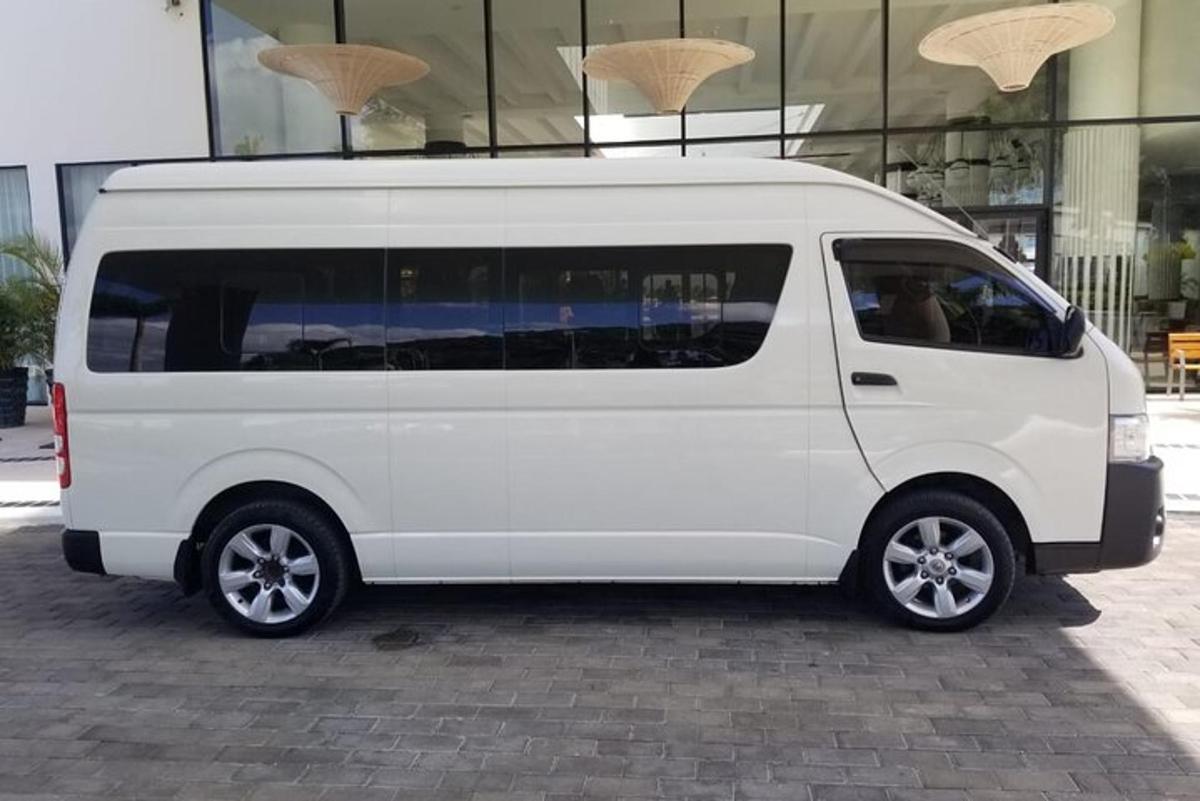 uma van branca estacionada em frente a um prédio