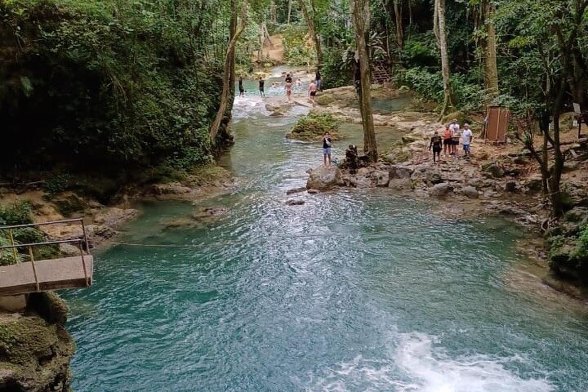 un gruppo di persone in piedi sulla riva di un fiume
