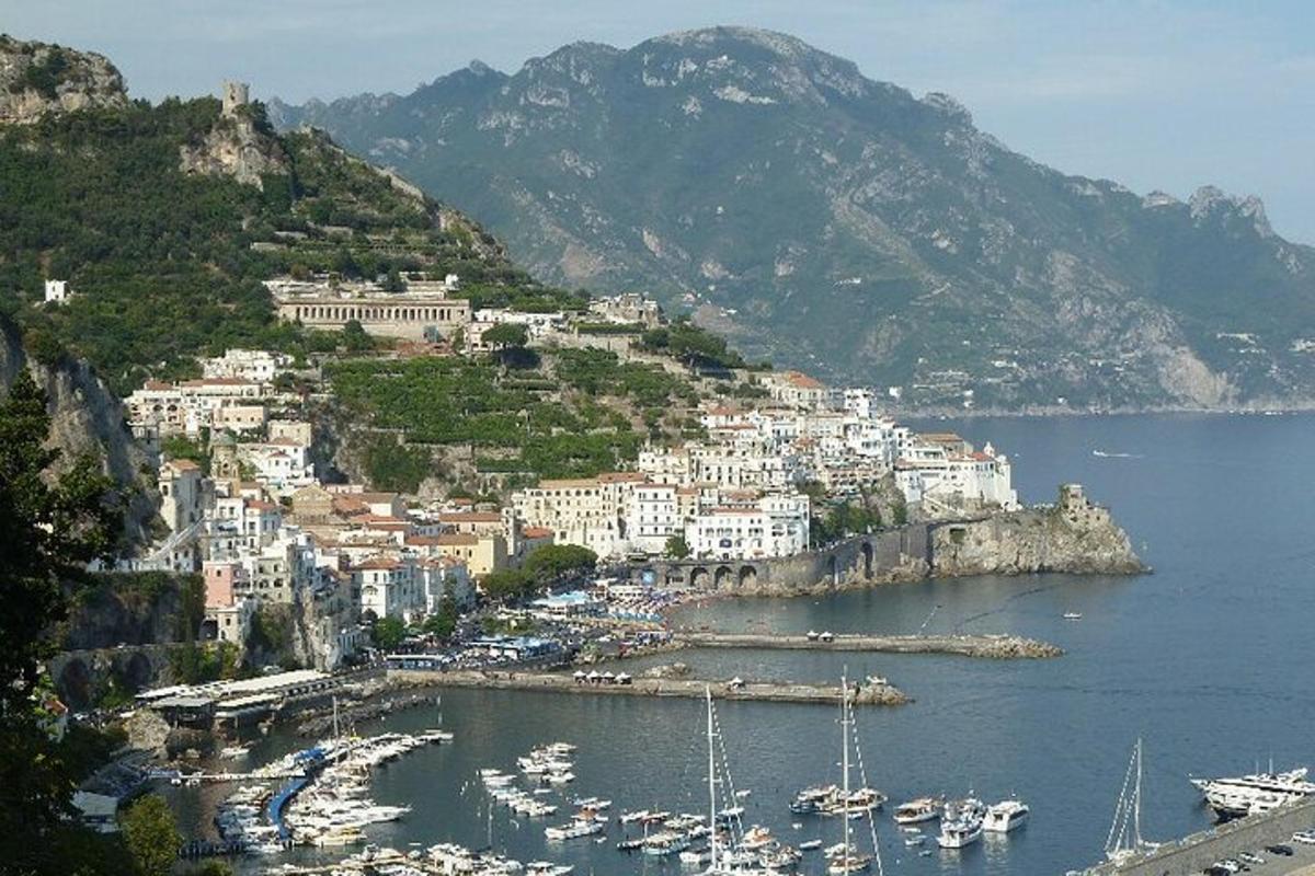 μια πόλη σε έναν λόφο με βάρκες στο νερό