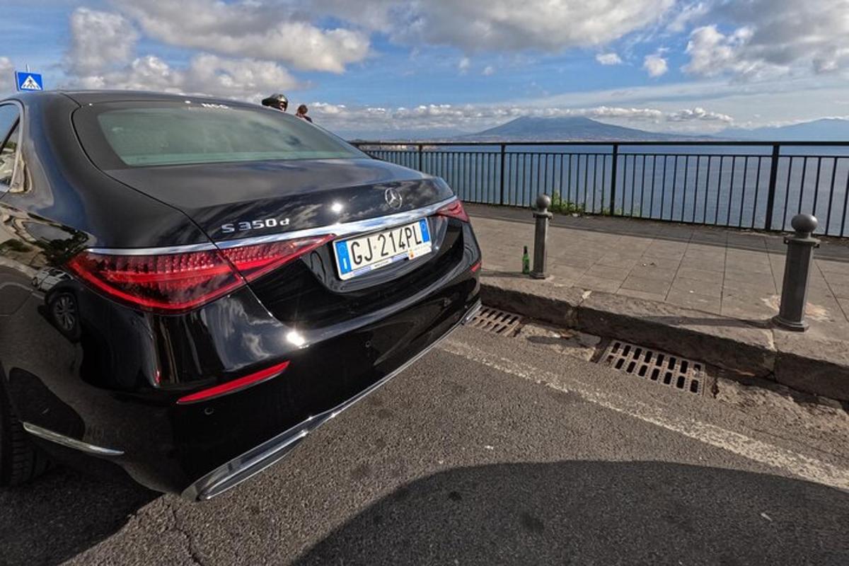 een zwarte auto geparkeerd op een parkeerplaats bij het water