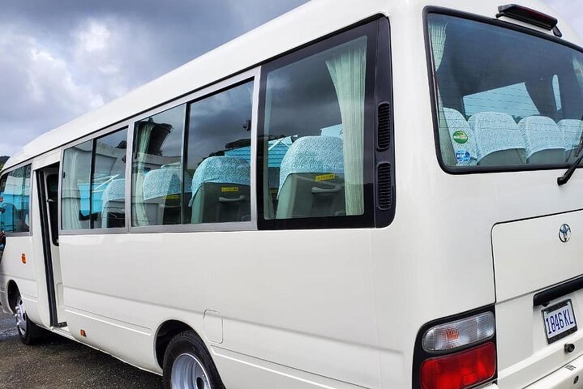 a white bus parked in a parking lot with seats