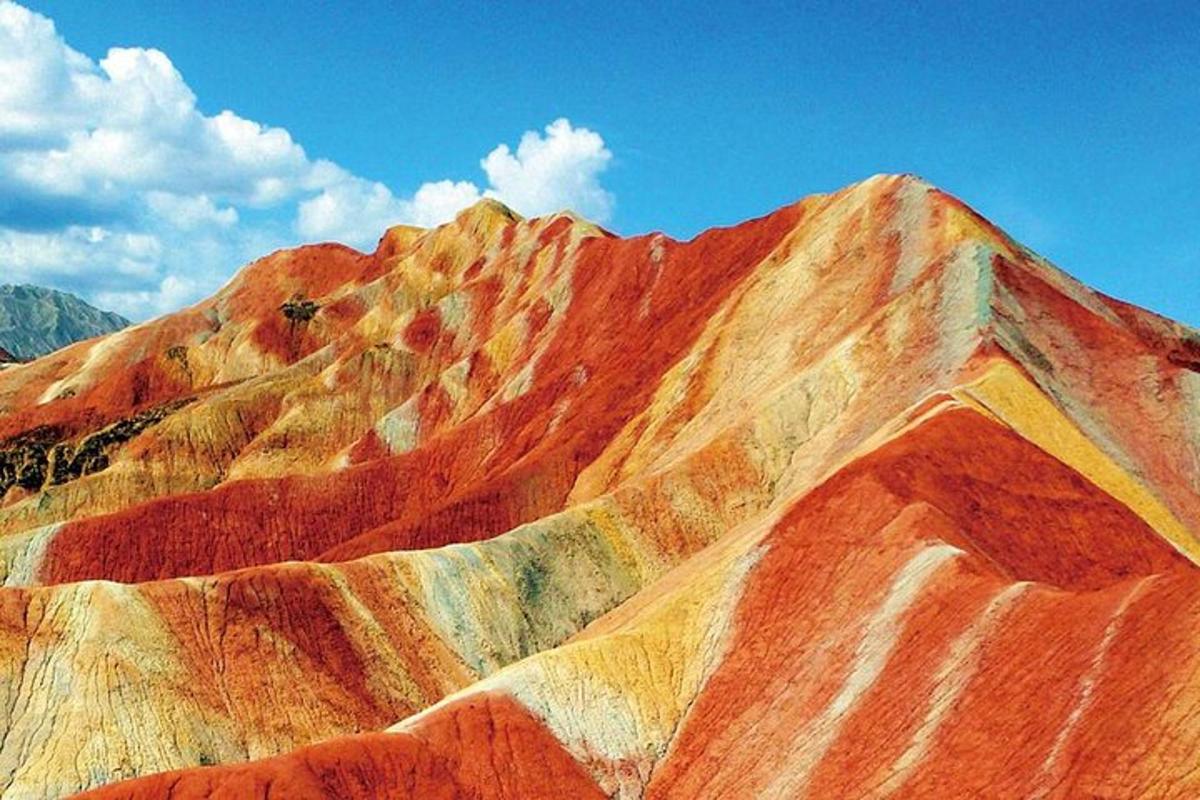 a view of a colorful mountain under a blue sky