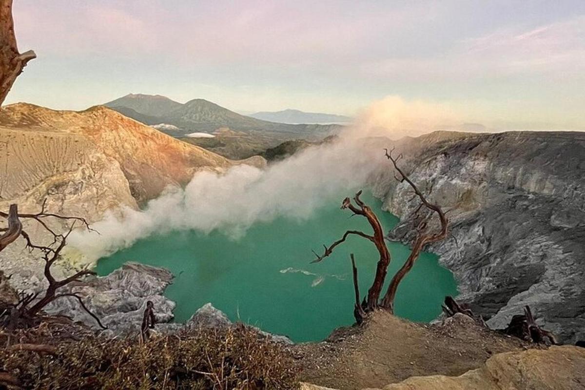a view of a green lake in the mountains
