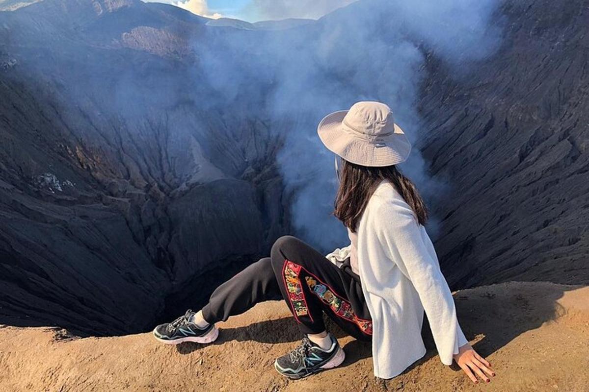 a woman sitting on the edge of a canyon
