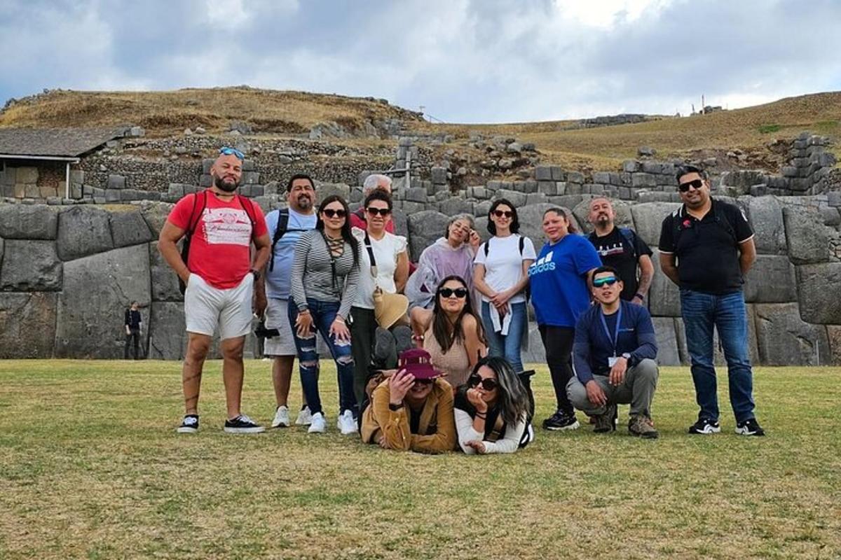 um grupo de pessoas posando para uma foto em frente a um muro de pedra