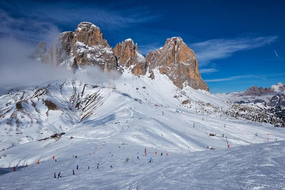 um grupo de pessoas esquiando montanha abaixo coberta de neve