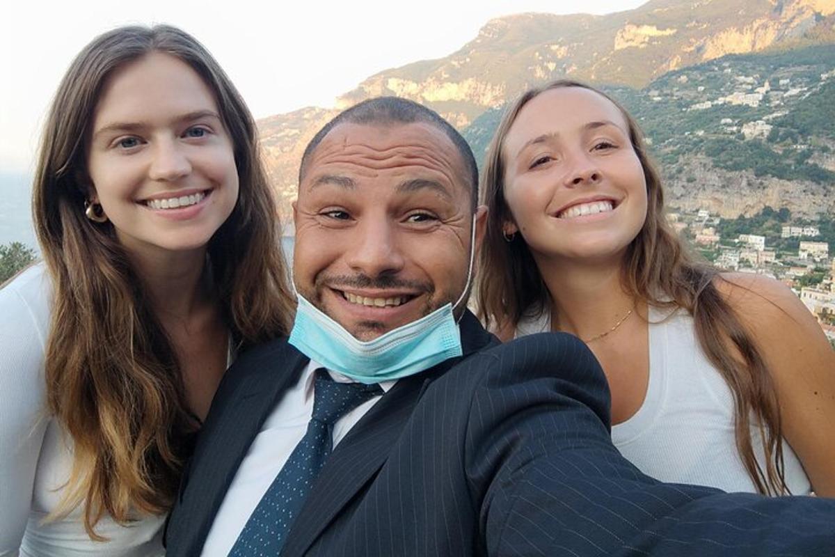 muž a dvě ženy pózují pro fotografii
