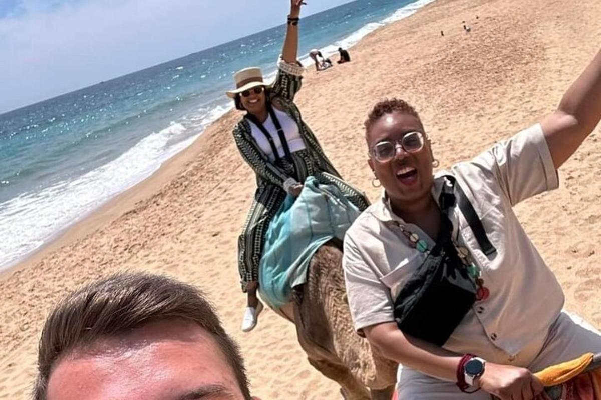 dues persones a la platja amb els braços enlaire