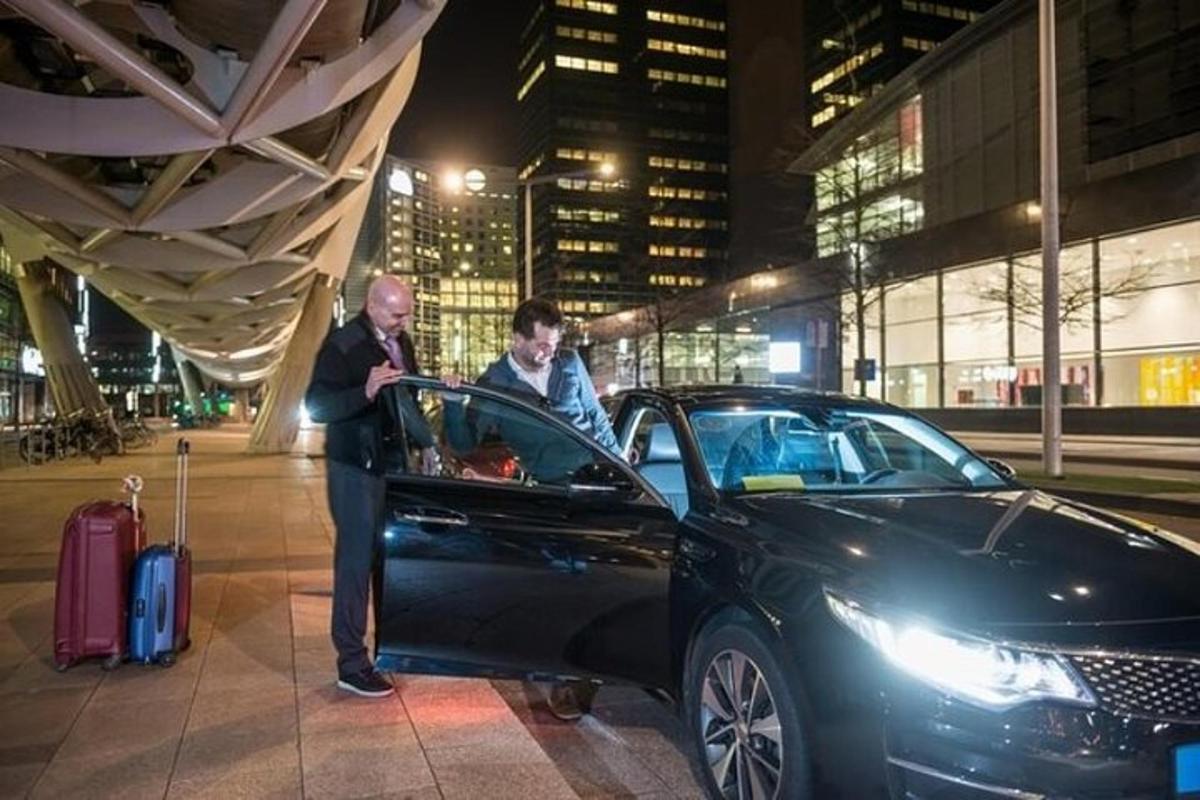 een man staat naast een zwarte auto